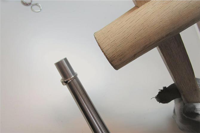 「芯金」という棒にリングを差し込み、木槌で調整する様子